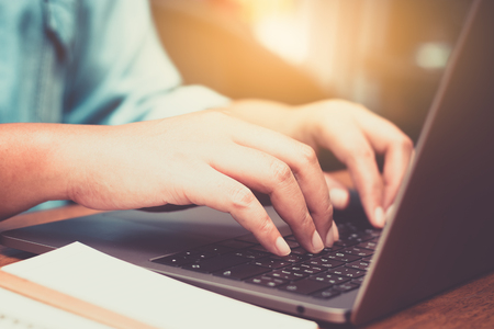 Hands typing on laptop in coffee shopの写真素材