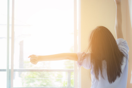 Happy Asian woman in the morning on bedの写真素材