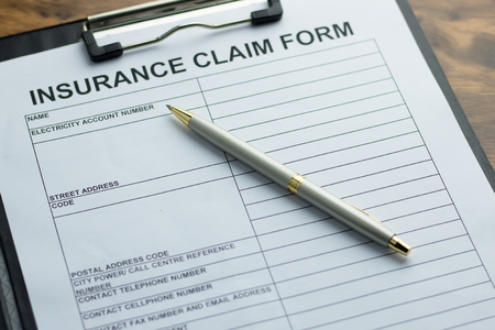 Insurance claim form with pen on  wooden table. selective focus