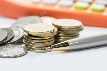 Pen and coins  selective focus