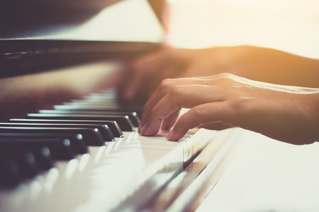 Close up of happy woman's hand playing the piano in the morning.の写真素材