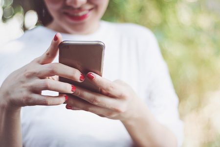 A woman are using smartphone in park.の写真素材