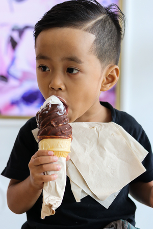Asian boy Eating ice cream happilyの写真素材