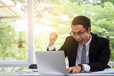 Happy success businessman are delighted with the success in notebook.business technology element and ecommerce concept.の写真素材