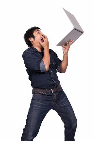 Asian business man shocked with a notebook on a white background.の写真素材