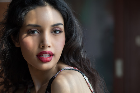 Close up of beautiful young woman looking camera in blurred backgroundの写真素材