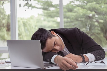 Businessman sleeping in office. The fatigue from workの写真素材