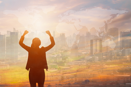 Double exposure of success business woman and city in sunsetの写真素材