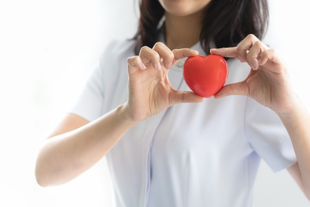 Nurse showing heart model in hospital