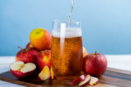 Fresh apple juice in the glass on wooden floor.の写真素材