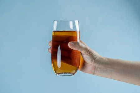 Hand holding Fresh apple juice in the glassの写真素材