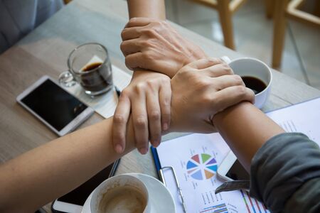 Hands were a collaboration concept of teamwork and working in co-working space in coffee shop