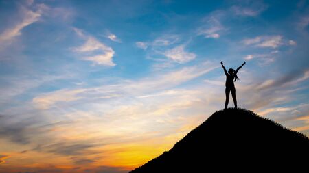 Silhouette woman on top hill in sunetの写真素材