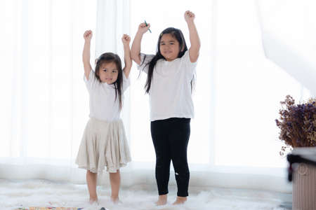 Happy Asian little girl playing in living room