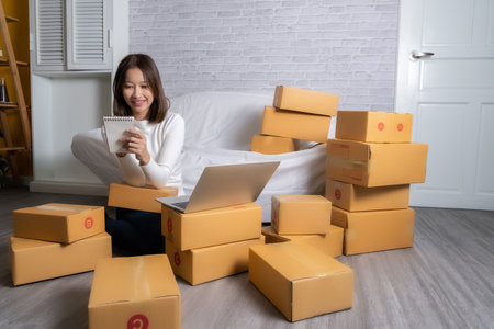 Beautiful Asian girl shop online are answering the customer email for delivery.の写真素材