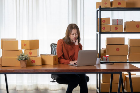 Beautiful Asian girl shop online are answering the customer email for delivery.の写真素材