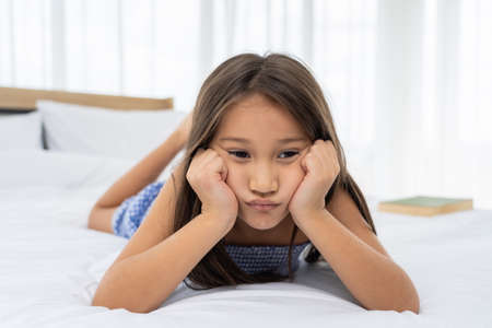 Asian girl on a white bed are sad and unhappy.の写真素材