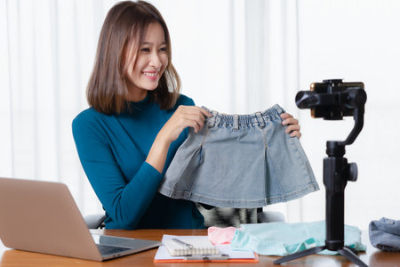 Beautiful Asian girl shop online are broadcasting live products via social media.の写真素材