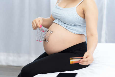 Close up of pregnant shopping baby products for childrenの写真素材