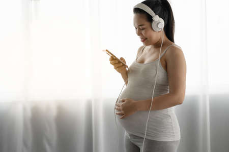 Pregnant women are listening to music for babyの写真素材