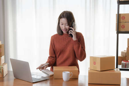Beautiful Asian girl shop online are answering the customer email for delivery.の写真素材