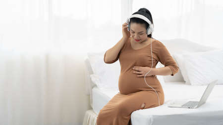 Pregnant women are listening to music for babyの写真素材