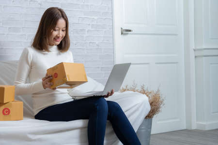 Beautiful Asian girl shop online are answering the customer email for delivery.の写真素材