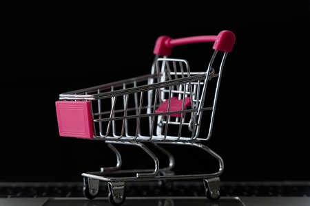 Shopping cart on laptop keyboard for e-commerce business concept.black backgroundの写真素材