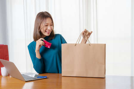 Happy Asian woman shopping online and paying by credit card.technology and ecommerce conceptの写真素材