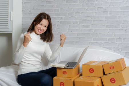 Beautiful Asian girl shop online are answering the customer email for delivery.の写真素材