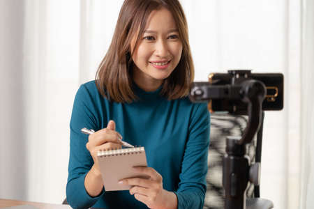Beautiful Asian girl shop online are broadcasting live products via social media.の写真素材
