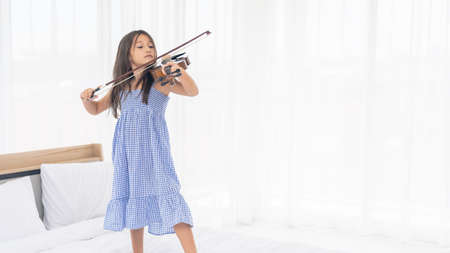 Happy Asian Girl are playing violin in the white room.の写真素材