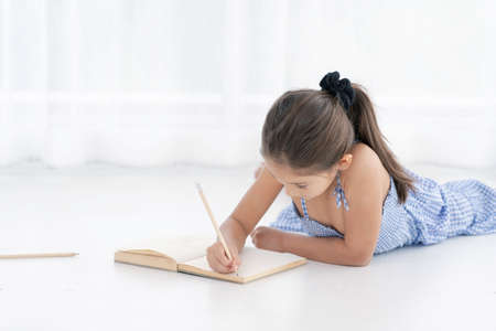 little cute girl write a paperの写真素材