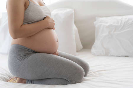 Happy Beautiful Asian pregnant on bedの写真素材