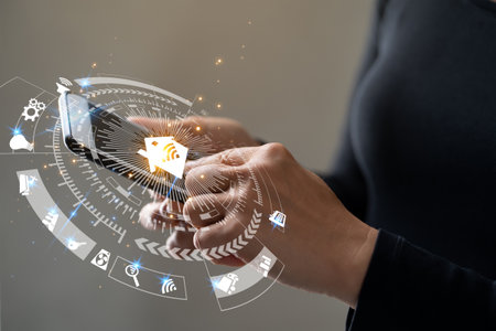 Woman hands using smart phone for mobile phone with smart home app in modern living roomの写真素材