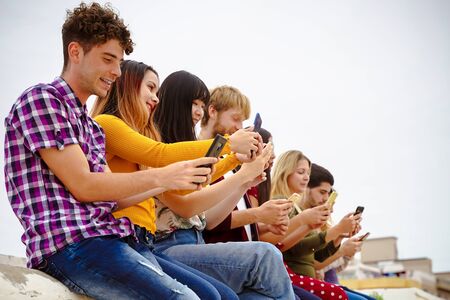 Teenagers watching videos and social media on smartphones - Addiction to new technology trends - Concept of youth, tech, social and friendship ? ?? Imageの写真素材