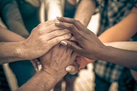 Young people putting their hands together. Friends with stack of hands showing unity and teamwork? Imageの写真素材