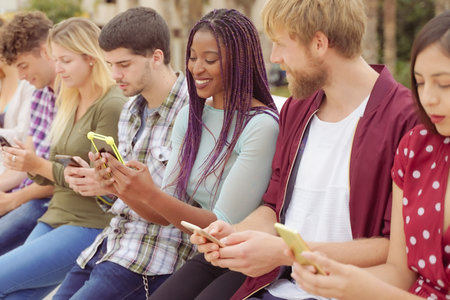 Group of friends watching smart mobile phones. Teenagers addiction to new technology trends. Concept of youth, tech, social and friendship.の写真素材