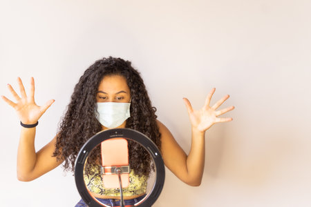 Influencer Girl blogger in medical mask talks about coronavirus. Woman recording video blog tells how to protect yourself from 2019-nCov. Job and medical concept.の写真素材