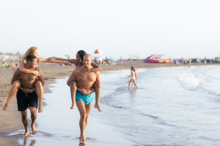 Group of best friends having fun at the beach. Happy tourists playing. Tourism, travel and relationship concept.の写真素材