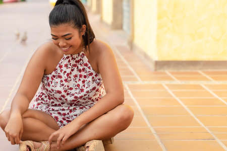 Portrait of happy young asian girl in good mood. Teenager sitting on the floor, dreaming in something great. Happy woman lost in her thoughts.の写真素材