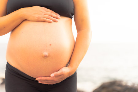 Young woman expecting a baby. Unrecognizable pregnant woman caressing her belly. Motherhood and pregnancy conceptの写真素材