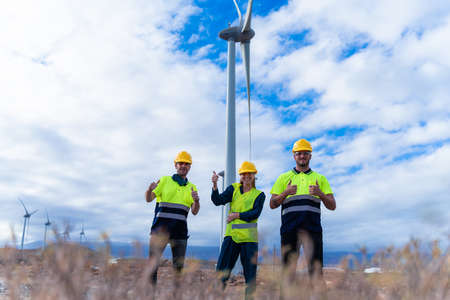 Happy engineers for their job. Skilled workers gives me a thumbs-up, smiles and looking the camera....