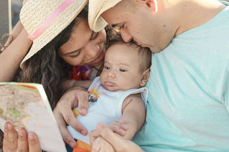 Smiling mother and father holding their newborn baby. Family concept.の写真素材