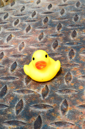 Yellow duck toy on steel floorの写真素材