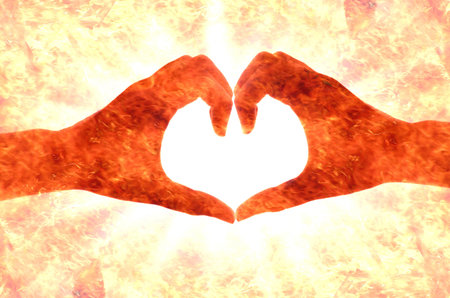 heart shape by hand (abstract fire background)の写真素材