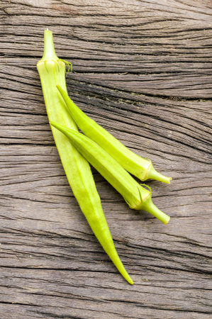 Okra on wooden floor (Abelmoschus esculentus)の写真素材