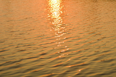 water surface with ripples and reflection of landscapeの写真素材