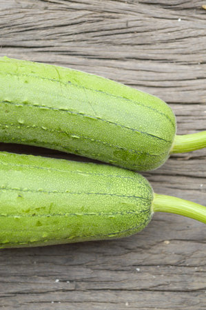 green Sponge Gourd on wooden floor (Luffa cylindrica)