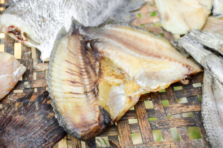 dry Nile tilapia salt fish on bamboo floor (Thailand raw food)
